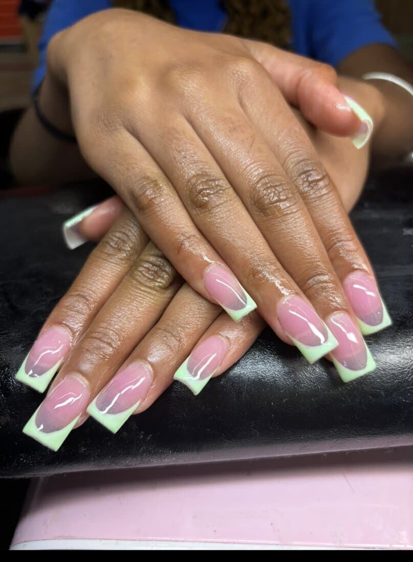Long square French-tip nails with a soft mint-green tip over a natural pink base, high-gloss finish by Talons by Byrd